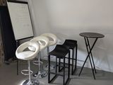 trois tabourets et une table dans un coin de la pièce