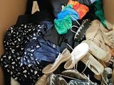 many pairs of shoes in a box with a teddy bear
