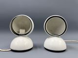 pair of white ceramic lamps with black bases on a gray background