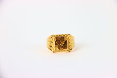 gros plan d'une bague en or sur une surface blanche