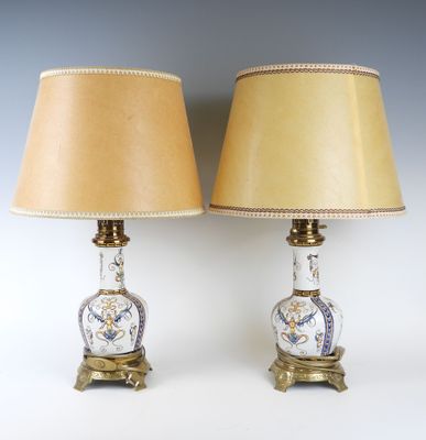une paire de lampes anciennes avec des abat-jours dorés et un vase bleu et blanc