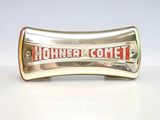une poignée argentée et rouge portant l'inscription « Hohner Comet »