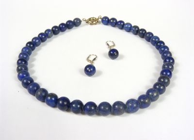 gros plan d'un collier et de boucles d'oreilles sur une surface blanche