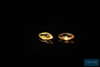 a pair of yellow sapphires on a black surface
