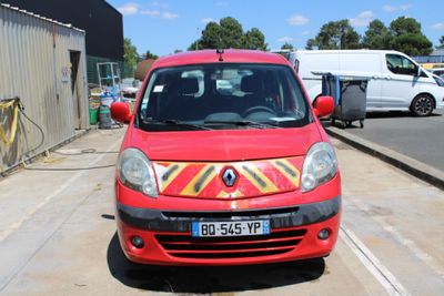 une petite voiture rouge garée sur le bord de la route