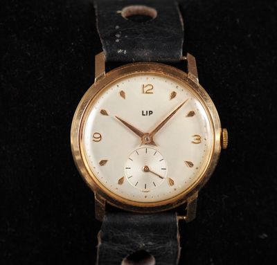 une image d'un gros plan d'une montre-bracelet sur une surface noire
