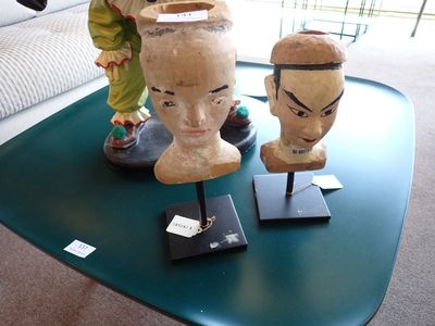deux vases posés sur une table, avec derrière eux une statue représentant un homme et une femme