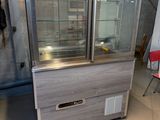 une vitrine au milieu d'une pièce avec une chaise rouge dans le coin