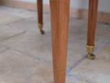 a cat that is sitting on the floor next to a table