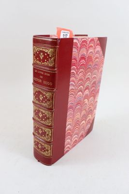 un livre rouge avec des bordures dorées et une couverture rouge