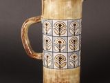 a brown and blue pitcher on a black table
