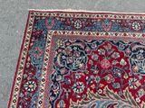 an image of a red and blue oriental rug on the ground