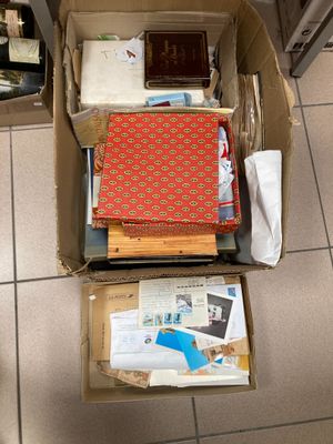 une boîte remplie de livres et de papiers posée par terre