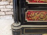 a black and gold chest of drawers with a clock on it