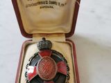 une médaille rouge et noire dans un écrin rouge