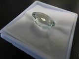 an image of a green diamond sitting on top of a white cloth