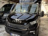 Une camionnette noire est garée dans un garage avec d'autres camionnettes.