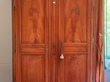 a large wooden armoire in the corner of a room