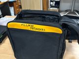 a black bag with a yellow label on it sitting on a desk