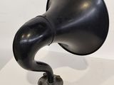 a black hornphone on a white table with a white background