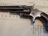 un vieux revolver posé sur une feuille de papier, sur une table