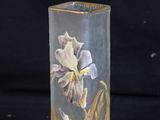 a glass vase with a flower on it on a black background