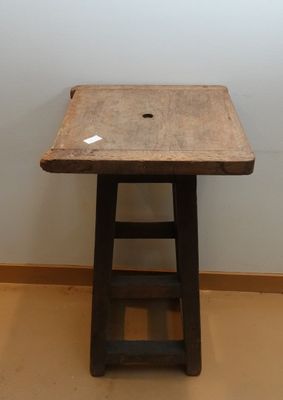 une petite table en bois avec un trou dans le plateau