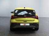 the rear end of a yellow car in a white room
