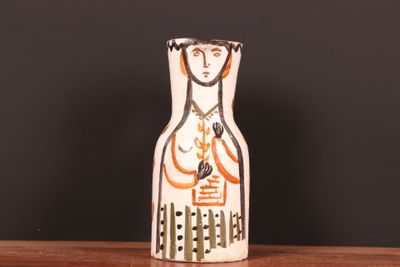 un petit vase décoré d'une peinture, posé sur une table