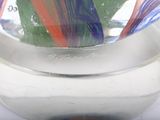 brightly colored marbles in a glass bowl on a white surface