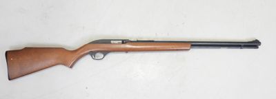 un fusil de chasse au canon en bois posé sur une surface blanche