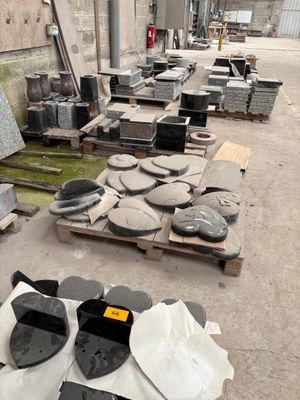 de nombreux blocs de granit sur une palette à côté d'un bâtiment