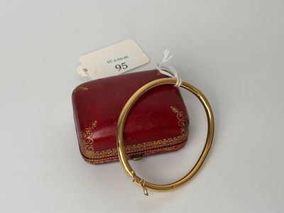 une image représentant un sac à main rouge orné d'une boucle dorée