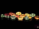 a close up of a bunch of different colored gems on a black surface