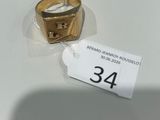 une bague en or posée sur une table blanche, avec une étiquette de prix