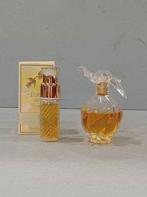 a small bottle of perfume next to a box of perfume