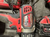 a corded drill and two other tools on the table
