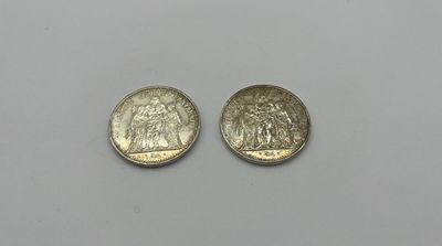 On voit deux pièces d'argent sur une surface blanche