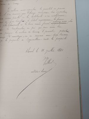 an open book with a handwritten letter on it sitting on top of a table