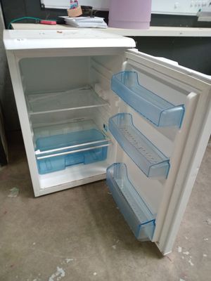 an open refrigerator that is sitting on the floor