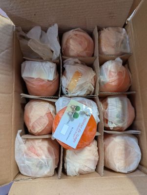 une boîte en carton remplie d'oranges et emballée dans du film alimentaire