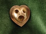 a heart shaped metal object on a green cloth