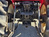 a red tractor that is parked in a lot