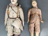 pair of antique dolls of two men in military uniforms on a gray surface