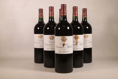 quatre bouteilles de vin rouge sont alignées sur une table