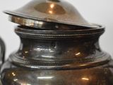 a close up of a silver tea pot with a lid