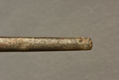 a close up of a piece of metal with a piece of wood sticking out of it