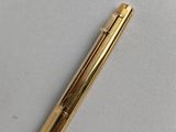 a gold pen sitting on top of a white surface