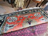 two rugs on the floor next to a chair