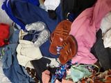 a pile of clothes that is sitting on a bed